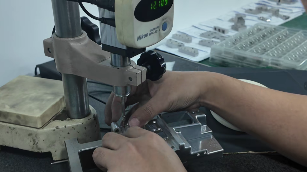 In-process dimensional inspection of CNC machined parts using a Nikon measuring device.