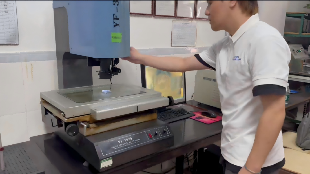 Rapid Efficient team member inspecting a CNC machined part using a video measuring system before delivery.