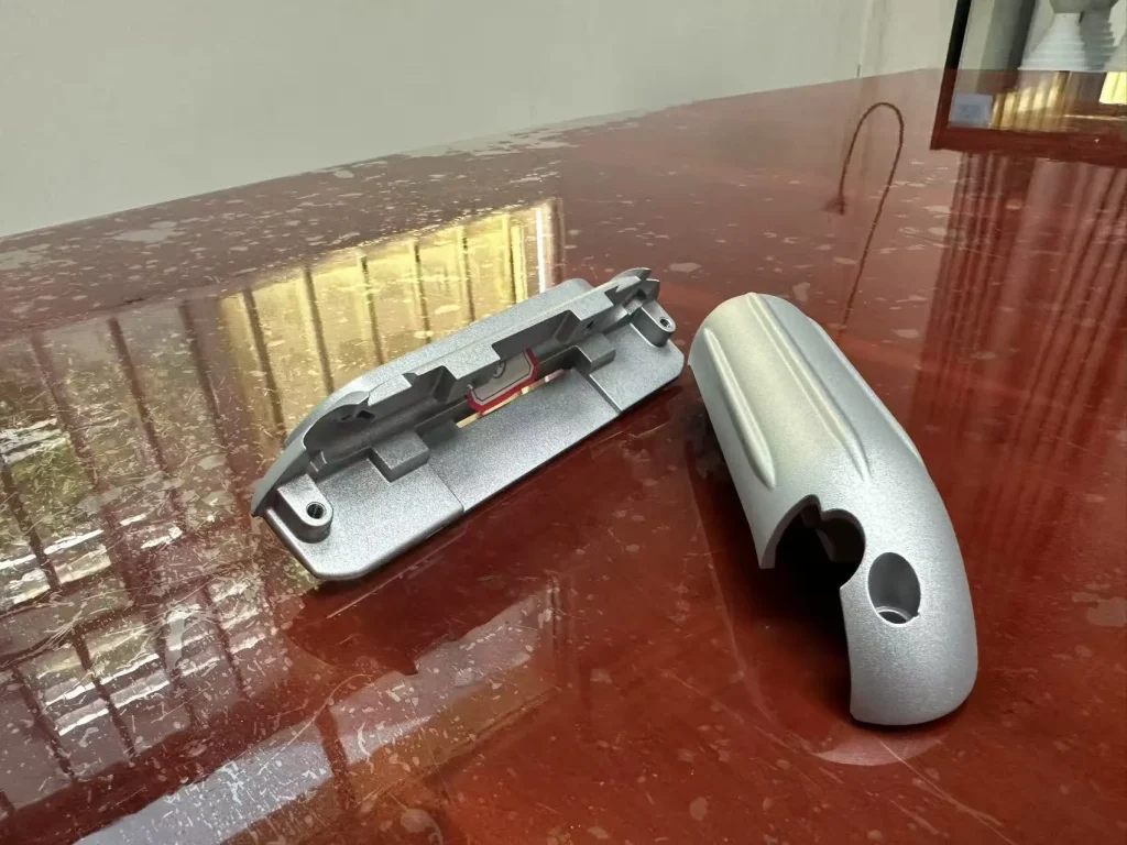 Textured aluminum housing parts showing a matte surface appearance for cosmetic-finish review.