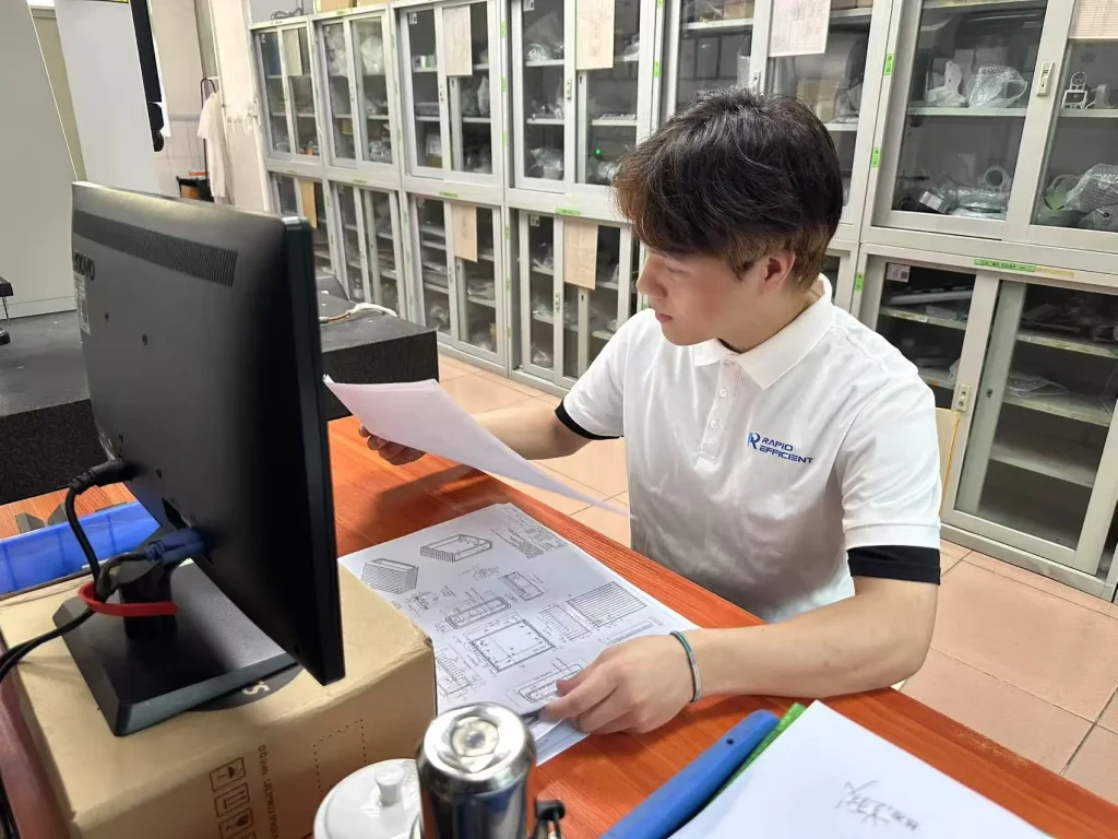 Engineer reviewing CNC machining drawings for custom CNC machining cost estimation in China.