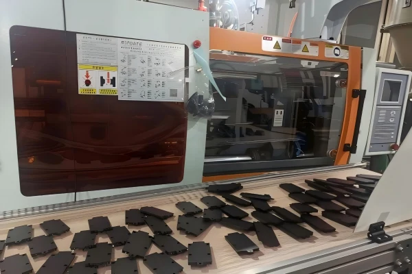 Injection molding production of custom plastic parts on an automated manufacturing line.