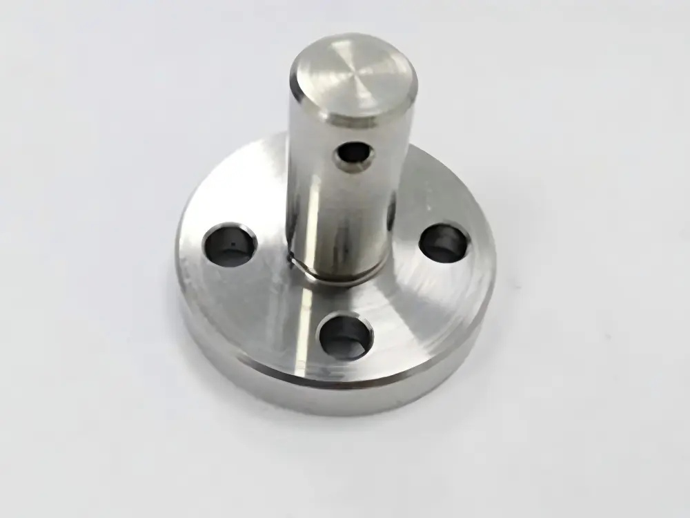 CNC turned flange pin with mounting holes and a cross-drilled cylindrical shaft.