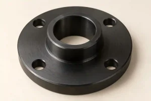 Black-finished steel flange with a central bore, raised locating shoulder, four mounting holes, and visible machining marks
