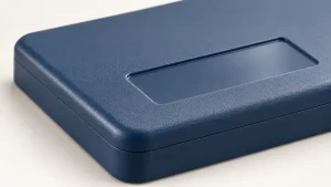 Illustration of a blue molded plastic enclosure with a textured exterior and a smooth recessed label area.