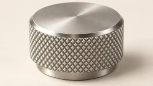 Illustration of a metal adjustment knob with a diamond-knurled grip band and a smooth turned top face.
